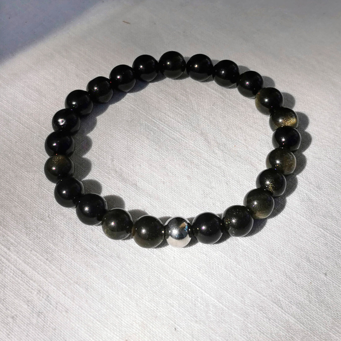 Bracelet en obsidienne dorée. En lithothérapie l'obsidienne dorée est décrite comme une pierre très puissante qui aide à l'introspection. Elle éloigne de vous toutes formes d'énergies négatives, elle vous agit comme un bouclier. C'est une pierre de protection.