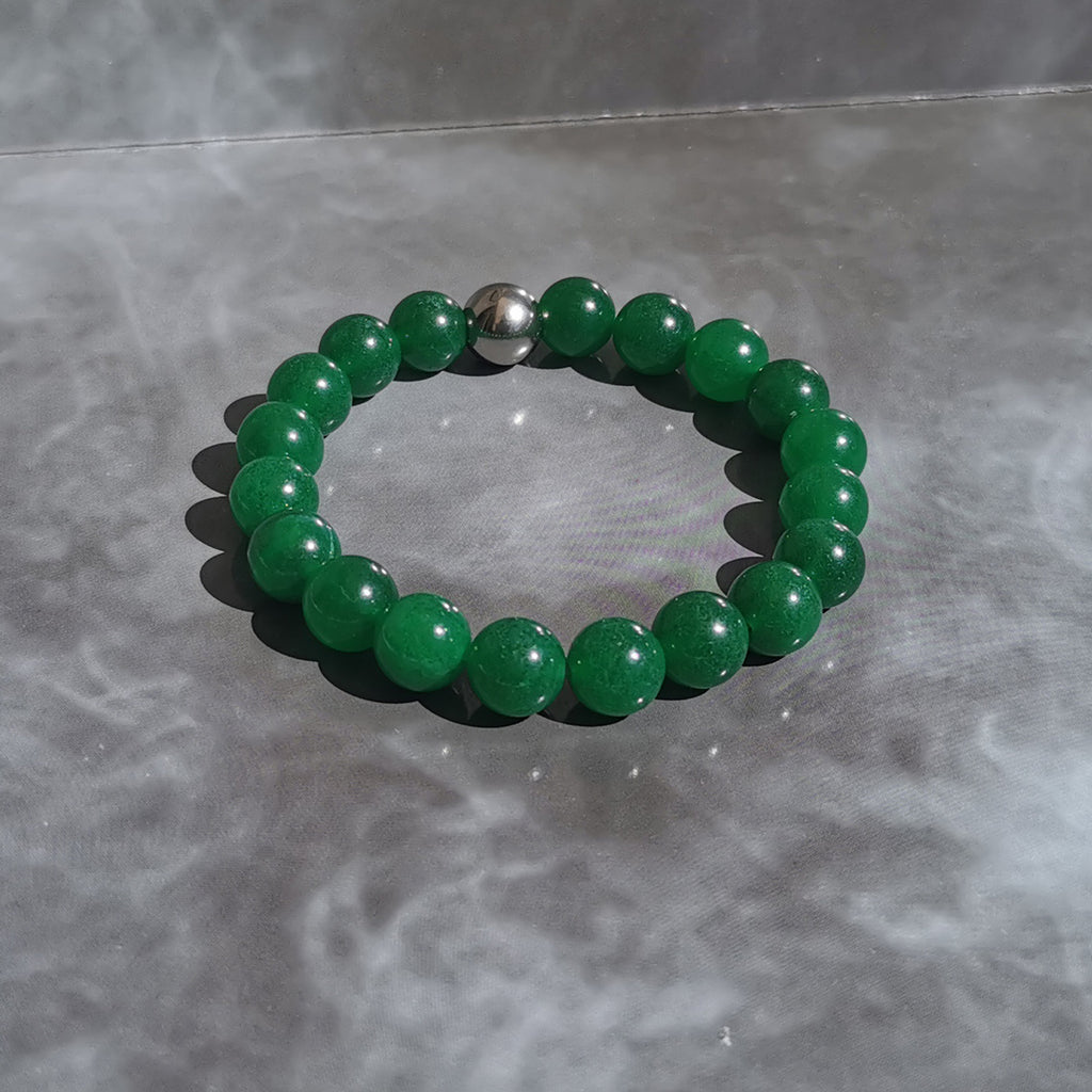 Bracelet élastique en Jade vert de Malaisie. Le jade de Malaisie est un nom commercial utilisé pour le quartz translucide qui a été teint de façon experte. Le jade de Malaisie est en fait du quartz. Perles de 10 mm.