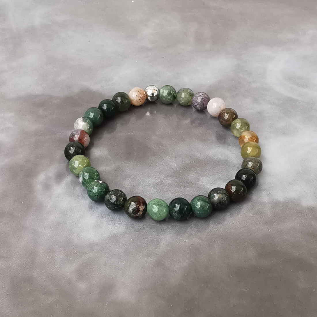 Bracelet monté sur fil de bijoutier élastique résistant. La bille d'acier chirurgical apporte une solidité supplémentaire.  Confectionné dans notre atelier en France. En lithothérapie l'Agate est une pierre de protection. Elle favoriserait la canalisation des émotions. Elle agit comme une barrière protectrice.