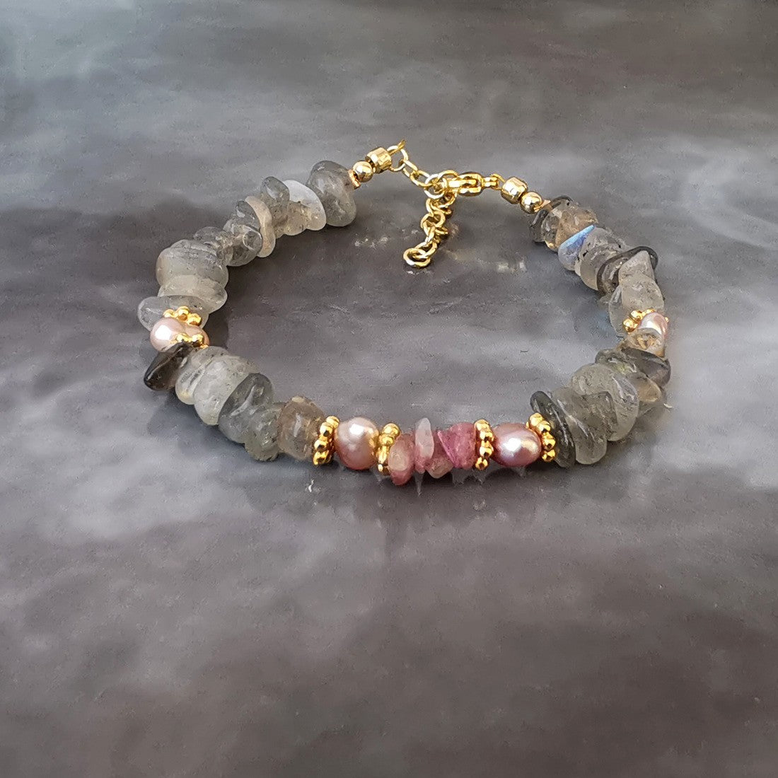 Création originale "ANAMOUR-bijoux".  Ce bracelet est monté sur un fil  d'acier gainé, avec des perles en:  labradorite,  tourmaline rose,  perle de culture rose.  Chainette de rallonge et autres apprêts en plaqué or 18k.