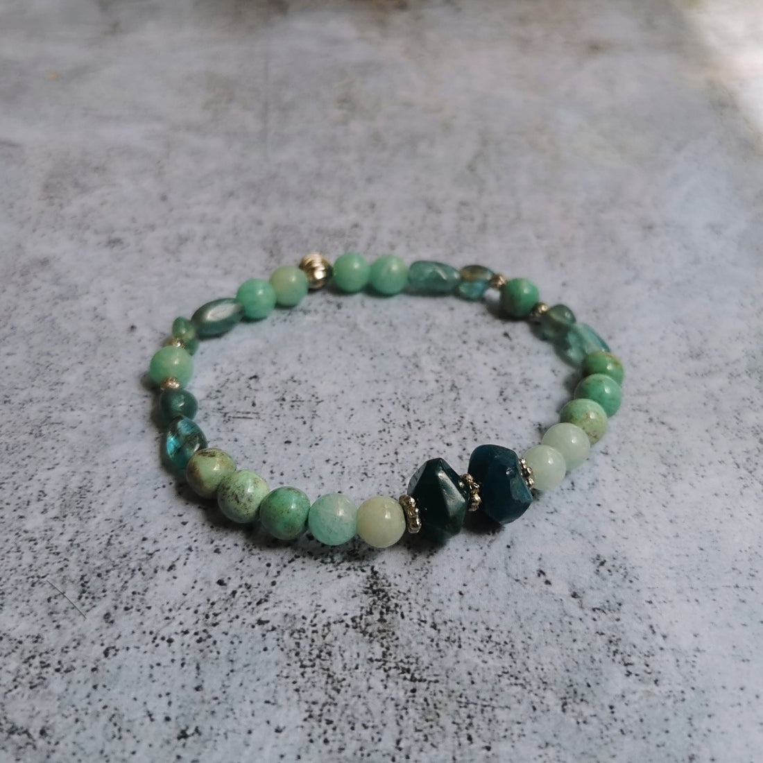 Pierres naturelles. Fabrication Française. Bracelet monté sur un fil de bijoutier en silicone de qualité premium, une bille d'acier vient parfaire son esthétique et sertir les nœuds pour une solidité maximum.  Composition: agate d'onyx vert ,2 rondelles d'apatite facettée, amazonite.