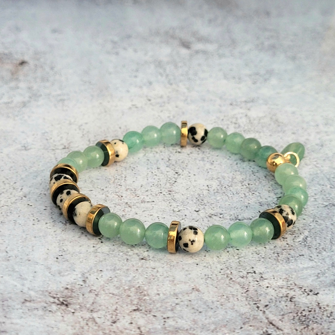 Bracelet femme aux jolies couleurs pastels. Composé de pierres semi-précieuses en aventurine verte, jaspe dalmatien et rondelles d'hématite dorées.