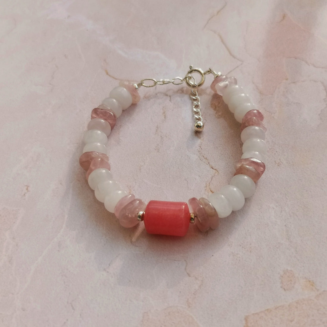 Bracelet de créateur français en pierres de gemme. Composé de rondelles de quartz rose et une pierre centrale en rhodochrosite. Son fermoir et sa chaine d'extension sont en argent 925.