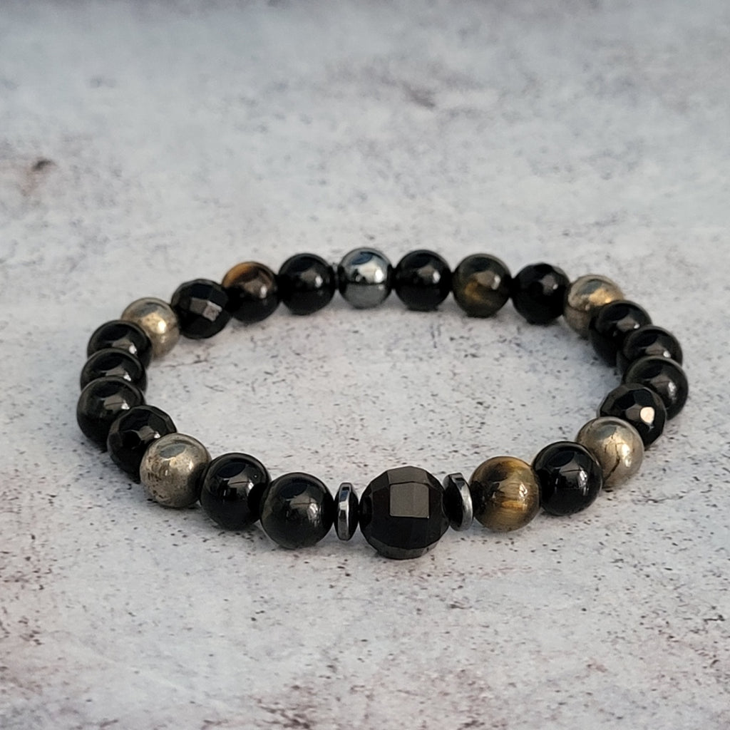 Magnifique bijou qui va aussi bien aux hommes qu'aux femmes. Ce bracelet est réalisé à la main avec des pierres naturelles. d'obsidienne, de pyrite et oeil de faucon