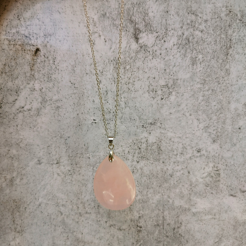 Collier pendentif goutte d'eau en pierre de quartz rose. Taille: 3.5 cm par 2.5 cm. Livré avec chaine en argent ou acier inoxydable , au choix.